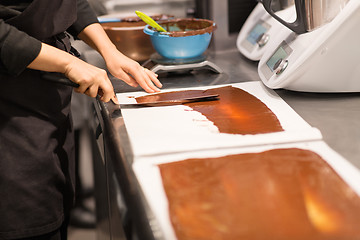 Image showing confectioner makes chocolate dessert at sweet-shop