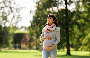 Image showing happy pregnant asian woman walking at park