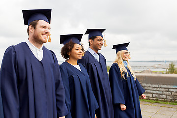 Image showing happy students or bachelors in mortar boards