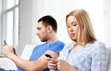 Image showing couple with smartphones at home