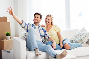 Image showing happy couple with cardboard boxes at new home