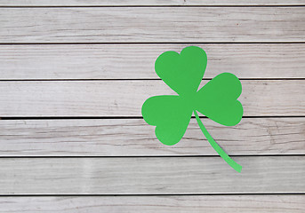 Image showing green paper shamrock on wooden background