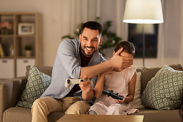 Image showing father and daughter playing video game at home