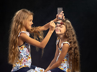 Image showing Girl puts powder on the forehead of another girl