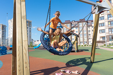 Image showing Two girls swinging strongly on a big round swing