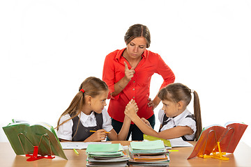 Image showing Teacher scolding schoolgirls fighting at a desk