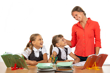 Image showing Kind teacher communicates with students sitting at a desk