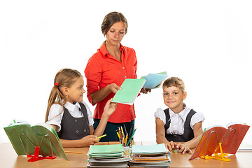 Image showing Pupils hand over notebooks with homework to teacher