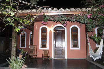 Image showing Porch of a colonial red house at night