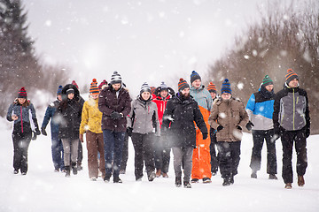 Image showing group of young people walking through beautiful winter landscape