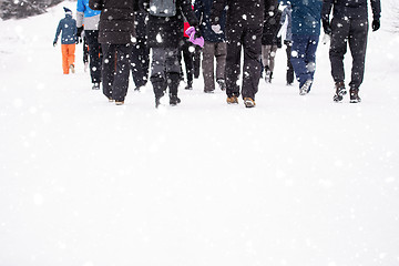 Image showing group of young people walking through beautiful winter landscape