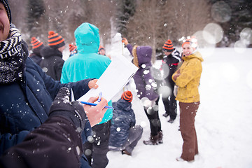 Image showing young people measuring the height of finished snowman