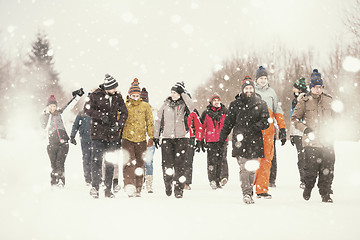 Image showing group of young people walking through beautiful winter landscape