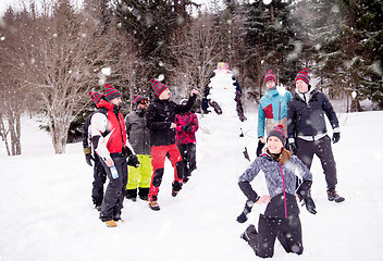 Image showing group portait of young people posing with snowman