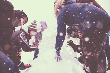 Image showing group of young people making a snowman