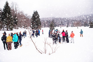 Image showing group of young people making a snowman