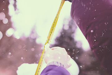 Image showing young people measuring the height of finished snowman