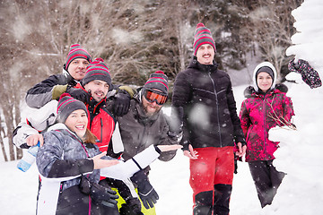 Image showing group portait of young people posing with snowman