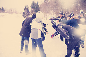 Image showing group of young people making a snowman