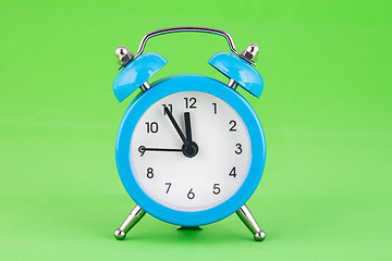 Image showing Classic alarm clock on a green background