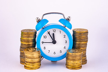 Image showing Clock and stacks of coins close-up