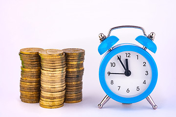 Image showing Clock and stacks of coins are close by, close-up