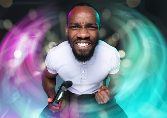 Image showing Enthusiastic gamer. Joyful young man holding a video game controller