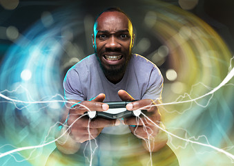 Image showing Enthusiastic gamer. Joyful young man holding a video game controller