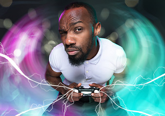 Image showing Enthusiastic gamer. Joyful young man holding a video game controller