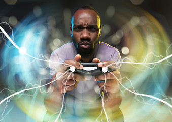 Image showing Enthusiastic gamer. Joyful young man holding a video game controller