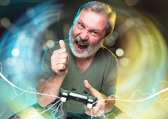 Image showing Enthusiastic gamer. Joyful man holding a video game controller