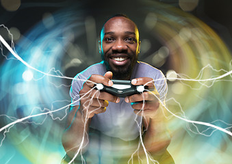 Image showing Enthusiastic gamer. Joyful young man holding a video game controller