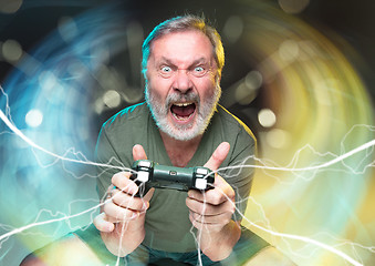 Image showing Enthusiastic gamer. Joyful man holding a video game controller