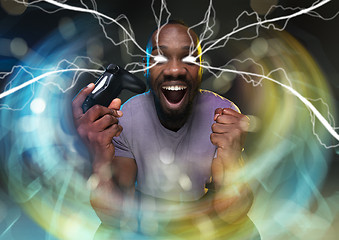 Image showing Enthusiastic gamer. Joyful young man holding a video game controller