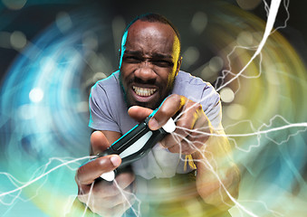 Image showing Enthusiastic gamer. Joyful young man holding a video game controller