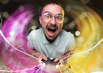 Image showing Enthusiastic gamer. Joyful young man holding a video game controller