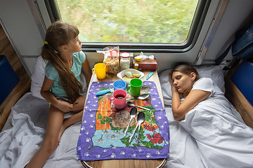 Image showing The situation on the train, mom is sleeping, daughter is looking out the window, top view