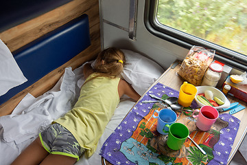 Image showing Girl sleeping on the bottom shelf in the train