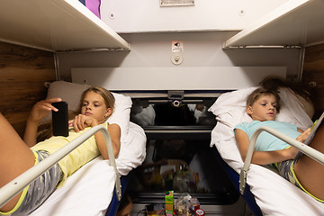 Image showing Children on the upper shelves of a reserved seat car do different activities