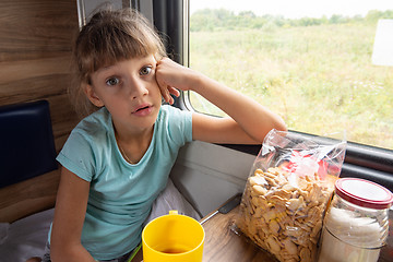 Image showing Girl sitting in a reserved seat carriage in a train funny looks in the frame