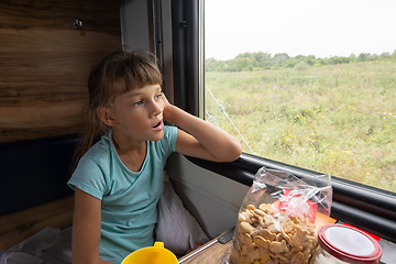 Image showing Girl sitting in a reserved seat yawning car looks out the window