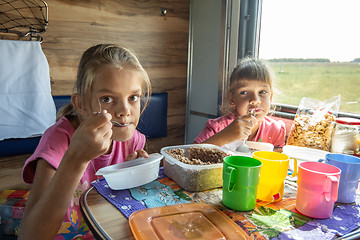 Image showing Two girls eat on the train