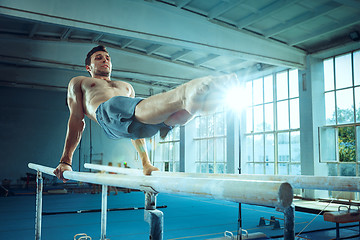 Image showing The sportsman during difficult exercise, sports gymnastics