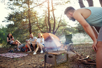 Image showing Party, camping of men and women group at forest. They relaxing, singing a song and cooking barbecue