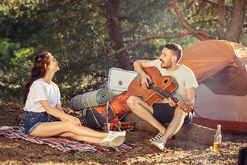 Image showing Party, camping of men and women group at forest. They relaxing, singing a song