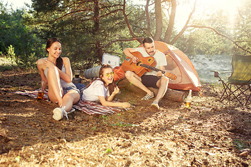 Image showing Party, camping of men and women group at forest. They relaxing, singing a song