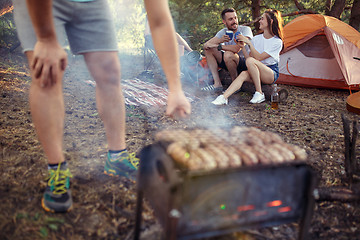 Image showing Party, camping of men and women group at forest. They relaxing, singing a song and cooking barbecue