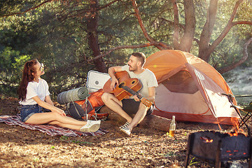 Image showing Party, camping of men and women group at forest. They relaxing, singing a song