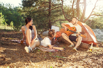 Image showing Party, camping of men and women group at forest. They relaxing, singing a song