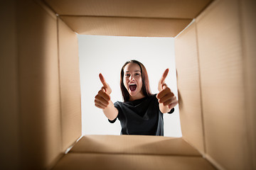 Image showing Woman unpacking and opening carton box and looking inside